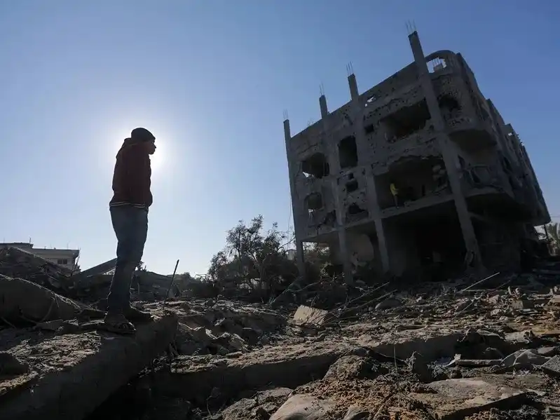 Palestinos inspeccionan una casa destruida tras un ataque aéreo israelí en un campo de refugiados en el centro de la Franja de Gaza.