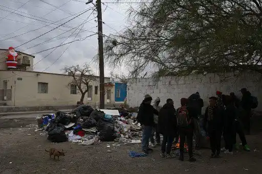 Migrantes de Venezuela se calientan junto a una fogata. 