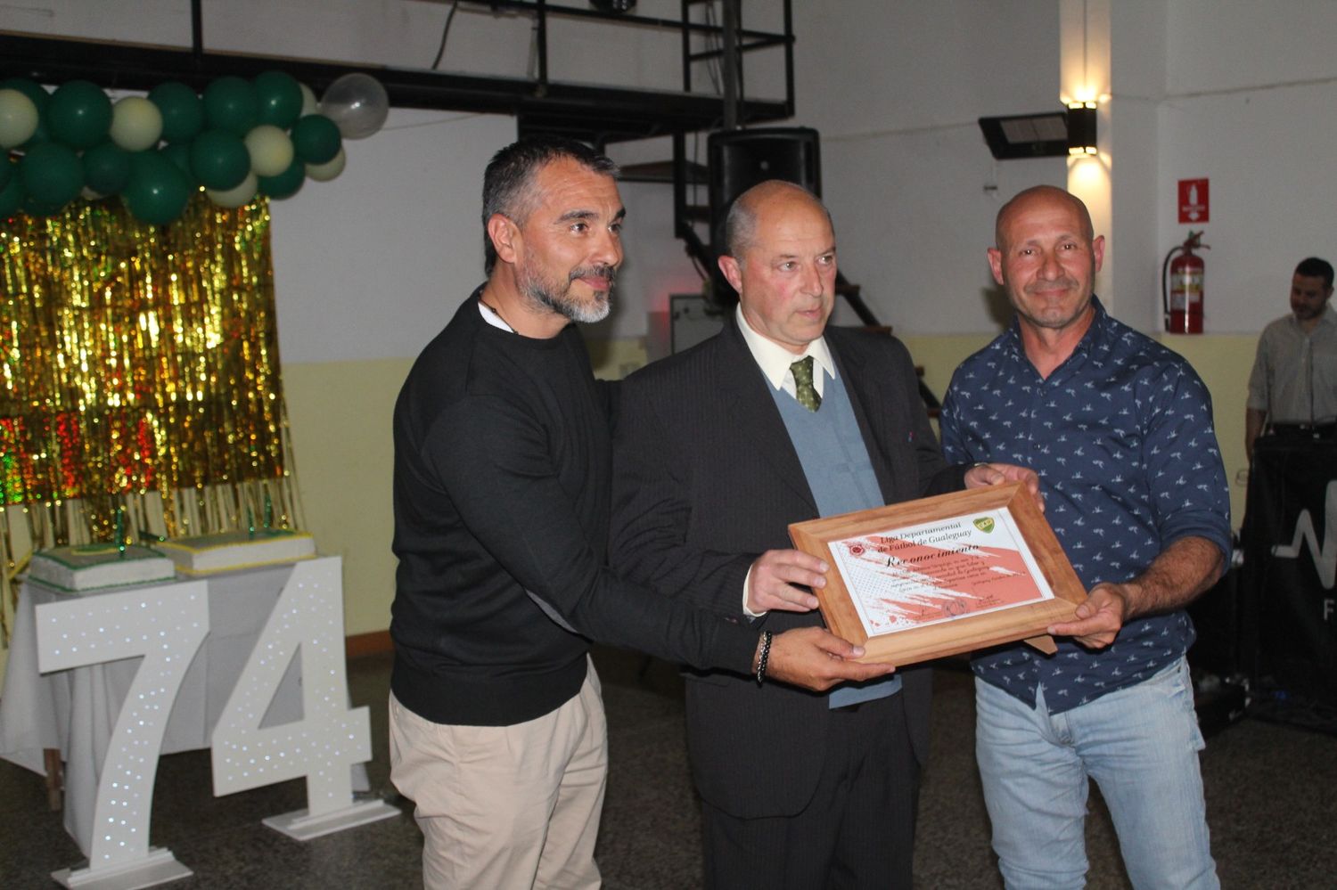 El presidente de la Liga Luis Cogorno y el vicepresidente Gerardo Berón haciéndole entrega de un recordatorio al presidente del C.A. Urquiza, Nicolino Rafael Nosiglia..