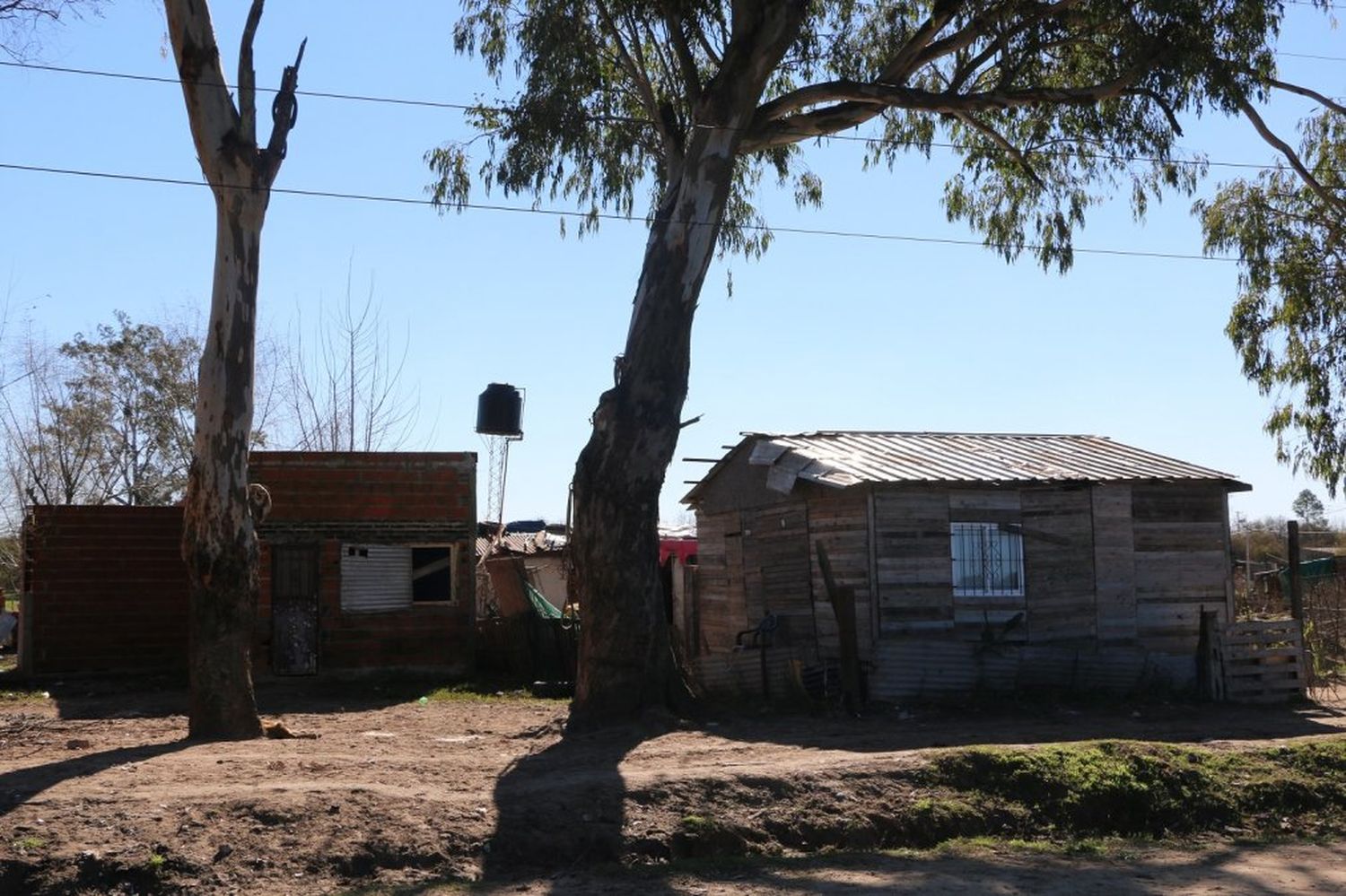 El barrio. Las precarias casas de material se mezclan con las de chapa, cartón y madera