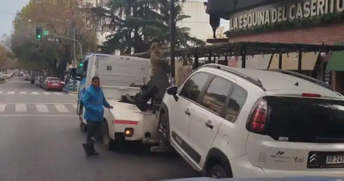 Estacionó en un lugar no permitido y para evitar que le lleven el auto se subió a una grúa y se cruzó de brazos.