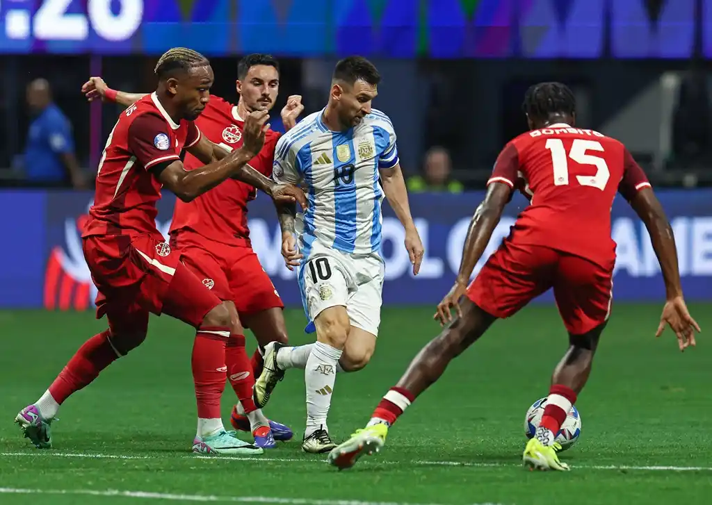 Messi maniobra entre varios canadienses.