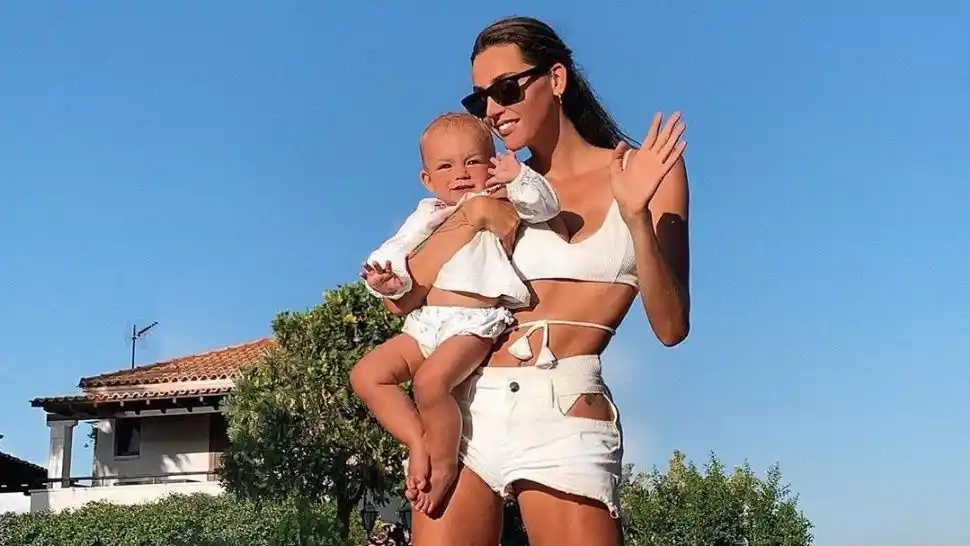 Mamá ninja: Cierra el baúl del auto con una patada y con su bebé en brazos