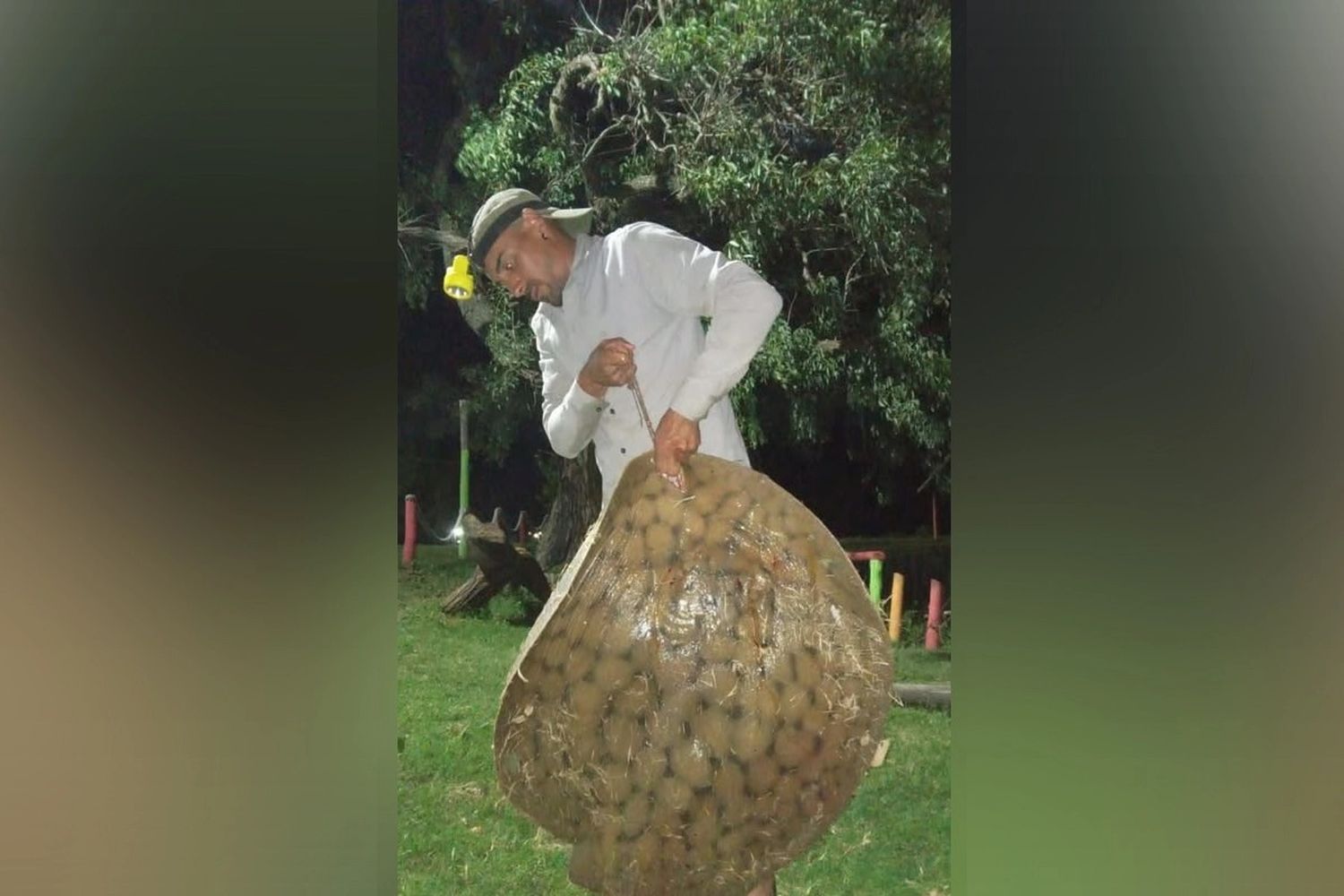 El hombre exhibe el ejemplar de raya que pescó.