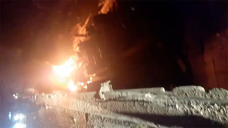 Un camión cargado con palos de madera cayó a un arroyo y se prendió fuego