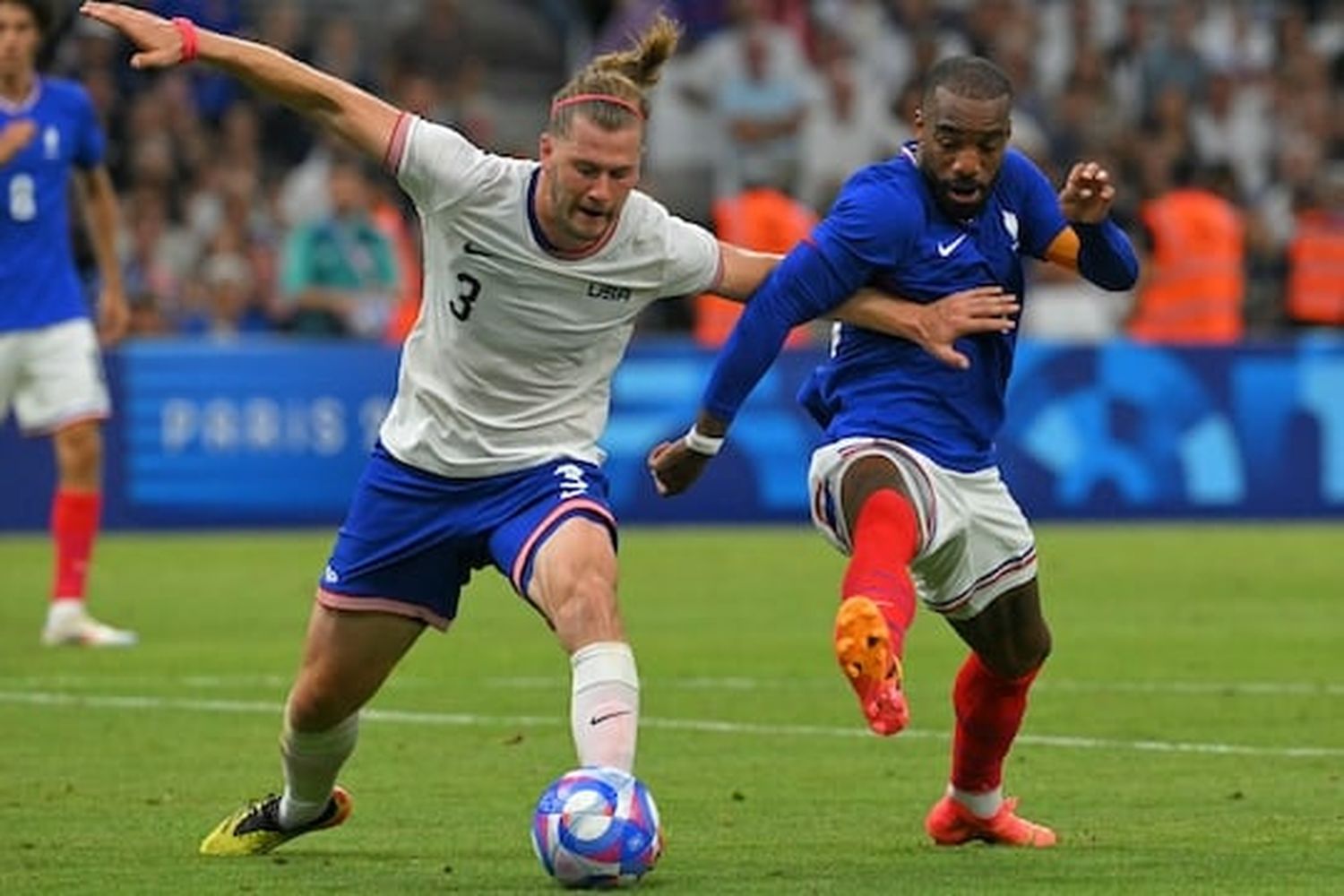 Walker Zimmerman, left, fights for the ball with France forward Alexandre Lacazette during their opening match at the Paris Olympics.