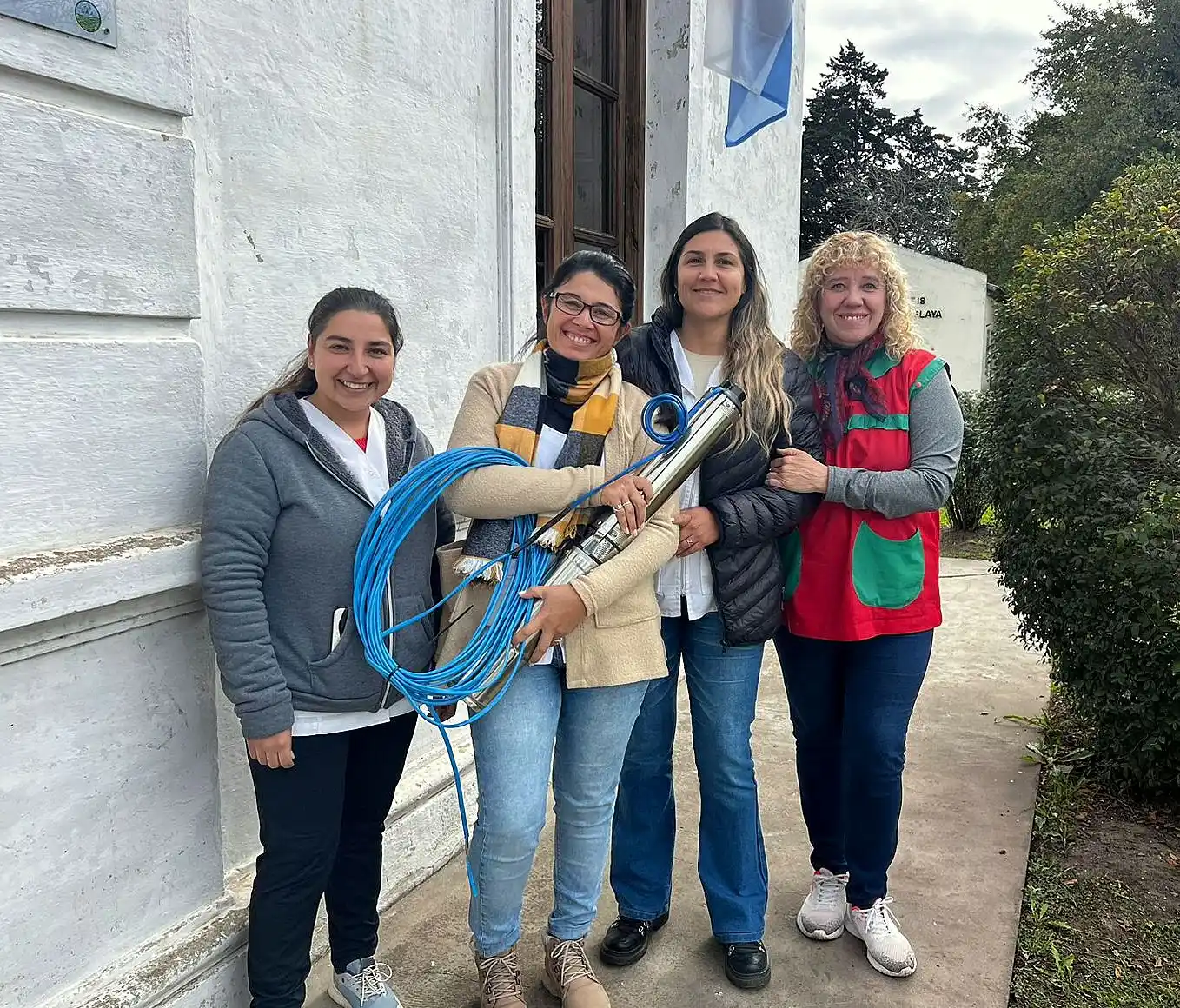 Docentes y directivos de la escuela luciendo la flamante bomba de agua.