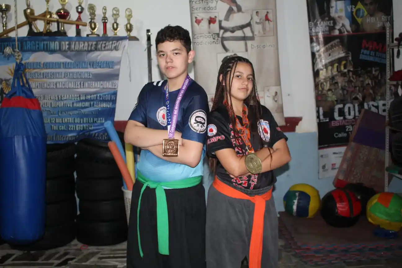 Mayra y Jeremías luciendo las medallas que ganaron en torneos mundiales de artes marciales.