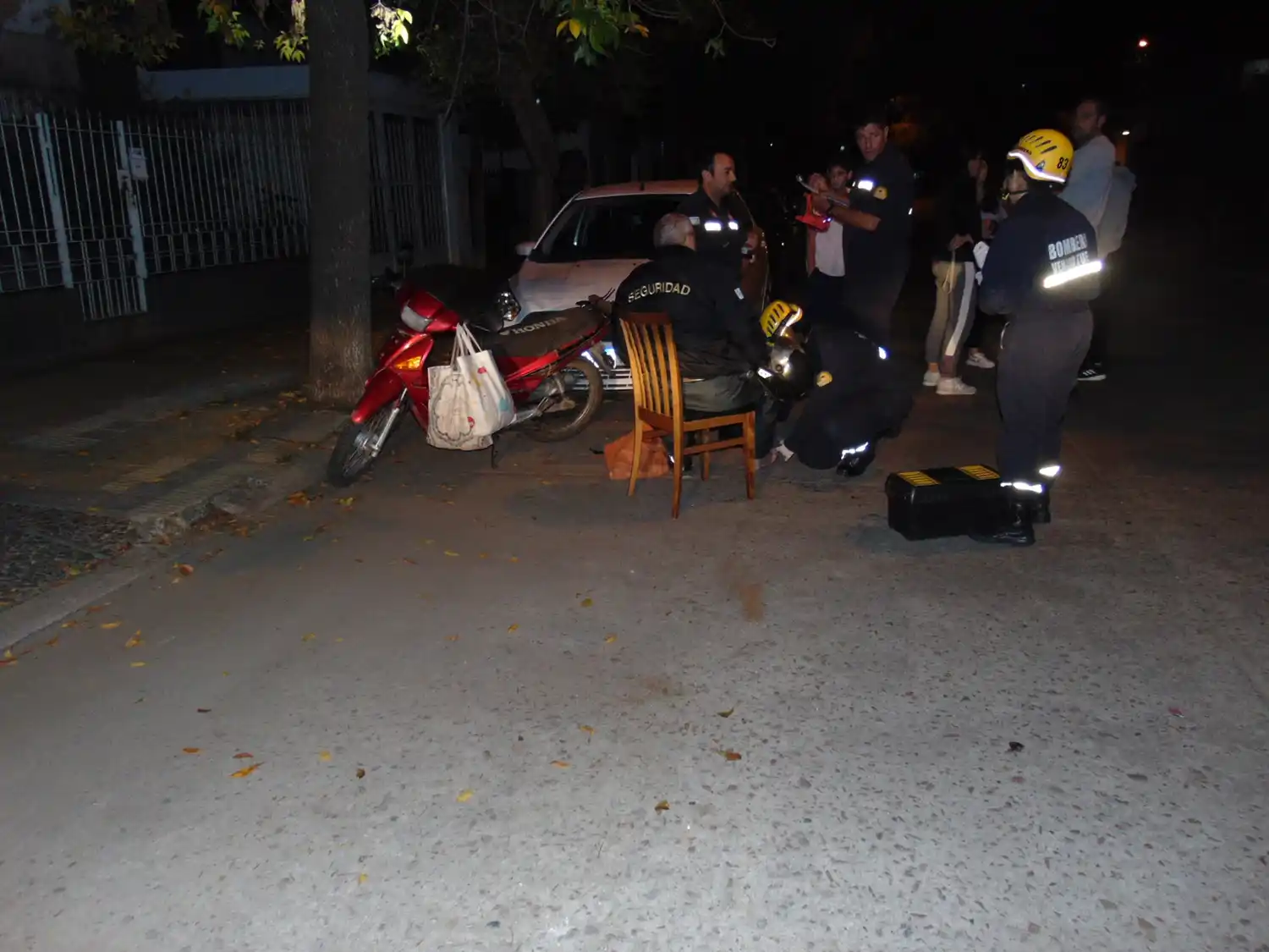 El motociclista sentando en un silla recibiendo asistencia médica.