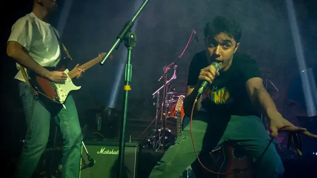 Un cantante sobre el escanrio mirando a cámara