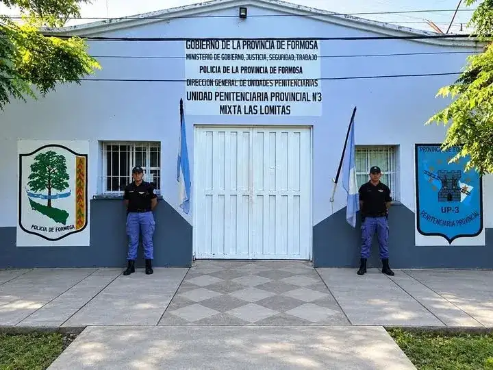 Dos efectivos de la Policía de Formosa custodian el ingreso a la Unidad Penitenciaria Nº 3 Mixta de Las Lomitas, donde se realizaron controles preventivos para evitar el ingreso de sustancias ilícitas al establecimiento carcelario provincial.