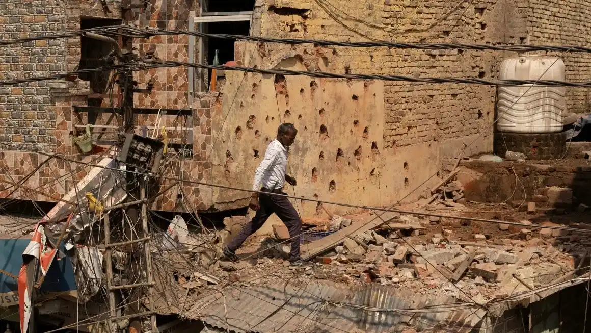 Un hombre pasa junto a una casa dañada por los ataques de Pakistán contra Jammu, ciudad de la Cachemira administrada por India, este sábado. (Adnan Abidi/Reuters)