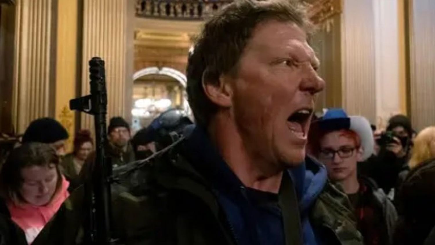 Un manifestante grita a la policía estatal de Michigan después de que los manifestantes ocuparon el edificio del capitolio estatal (REUTERS/Seth Herald)