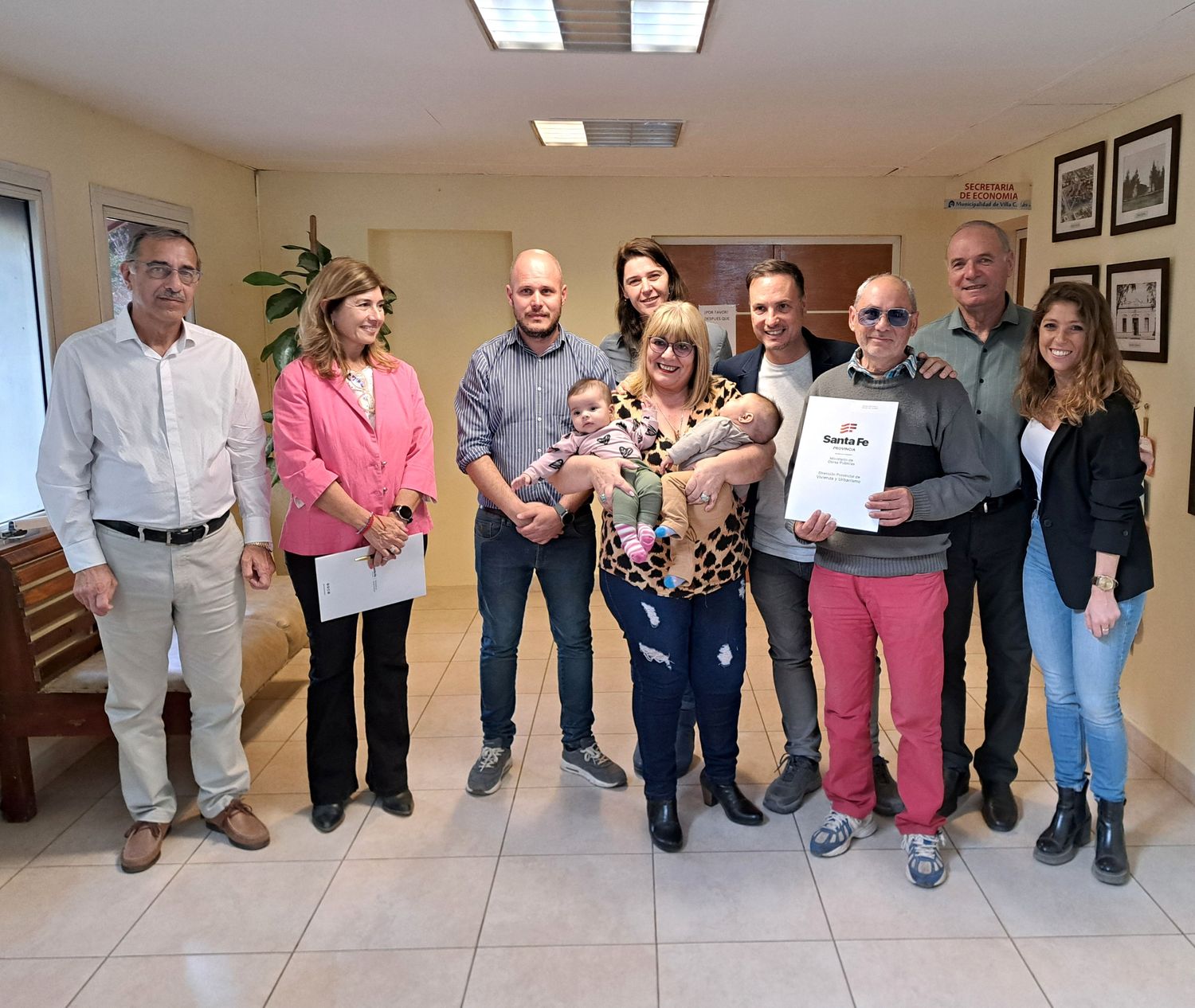 Familias felices recibiendo las escrituras de sus viviendas.