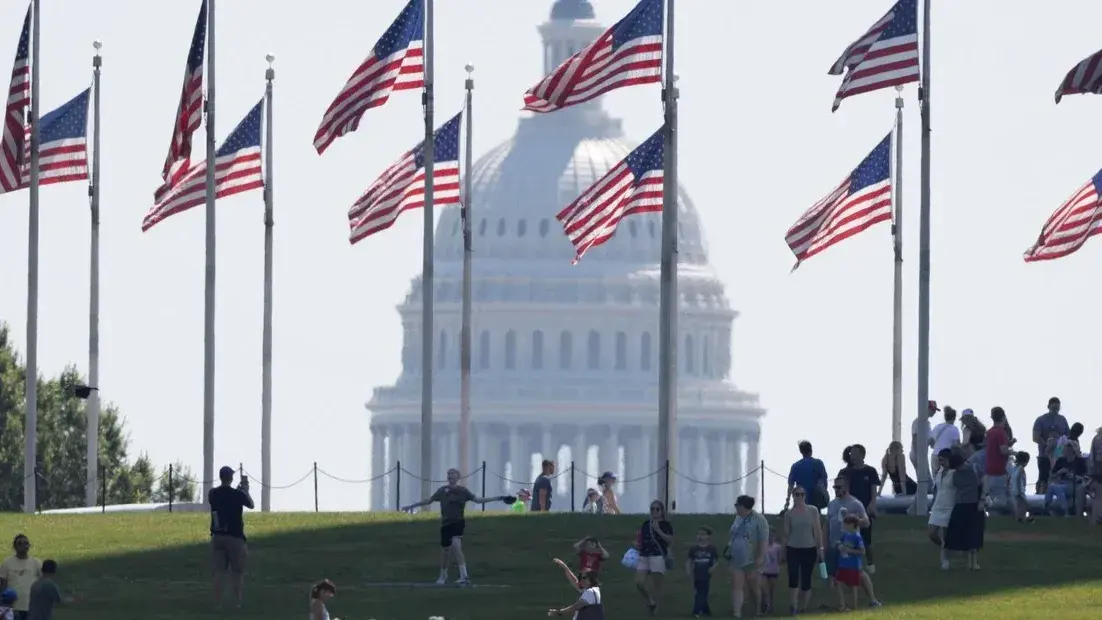 El Capitolio de Estados Unidos, en Washington D.C., con banderas estadounidenses en primer plano.