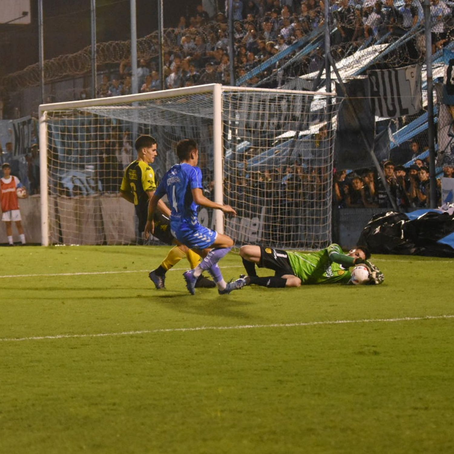 Temperini atrapa el balón ante la llegada de Palmieri y Rosales. (Foto prensa Temperley).