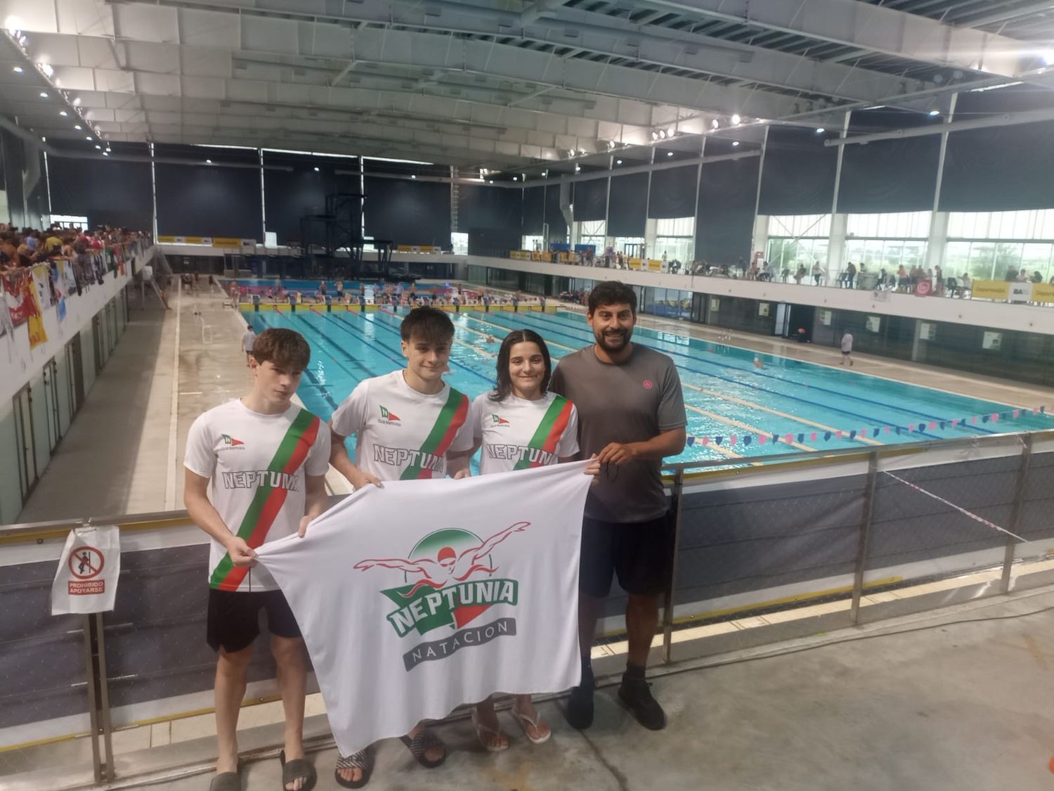 Los tres jóvenes nadadores junto al profesor Ferreyra.