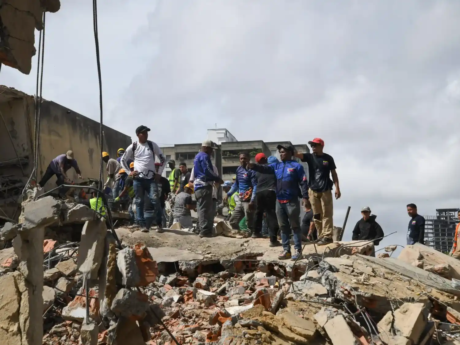 Rescatistas trabajan sobre los escombros de un edificio derrumbado.