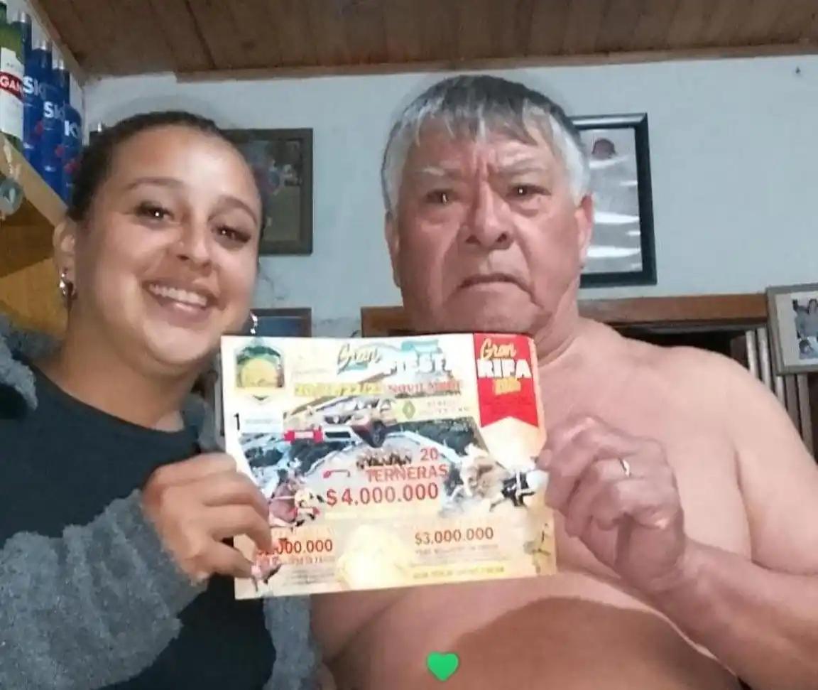 El ganador de la rifa junto a la joven que le vendió el número.