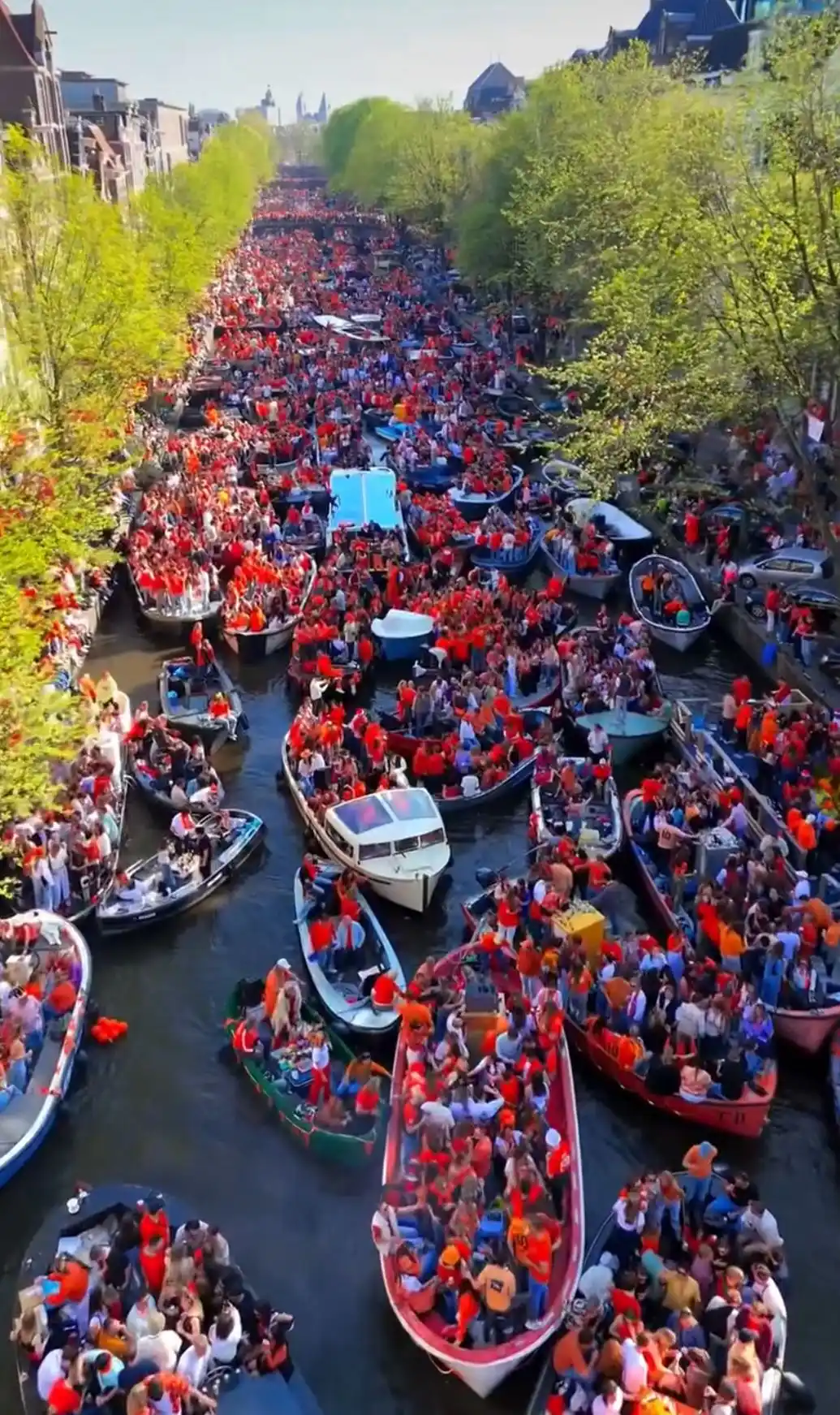 La fiesta del cumpleaños del rey con los canales llenos de botes color naranja-