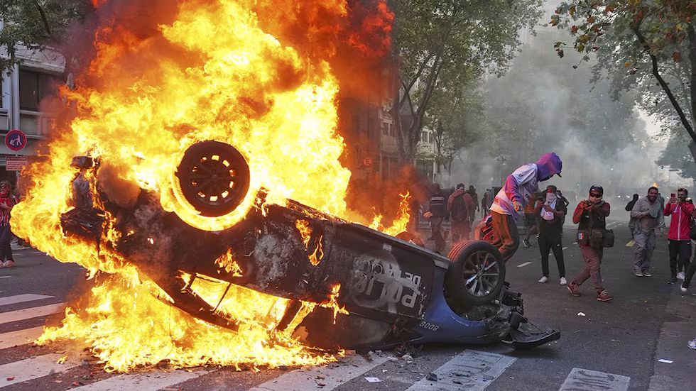 Un manifestante quema un patrullero durante la manifestación (foto: AP)