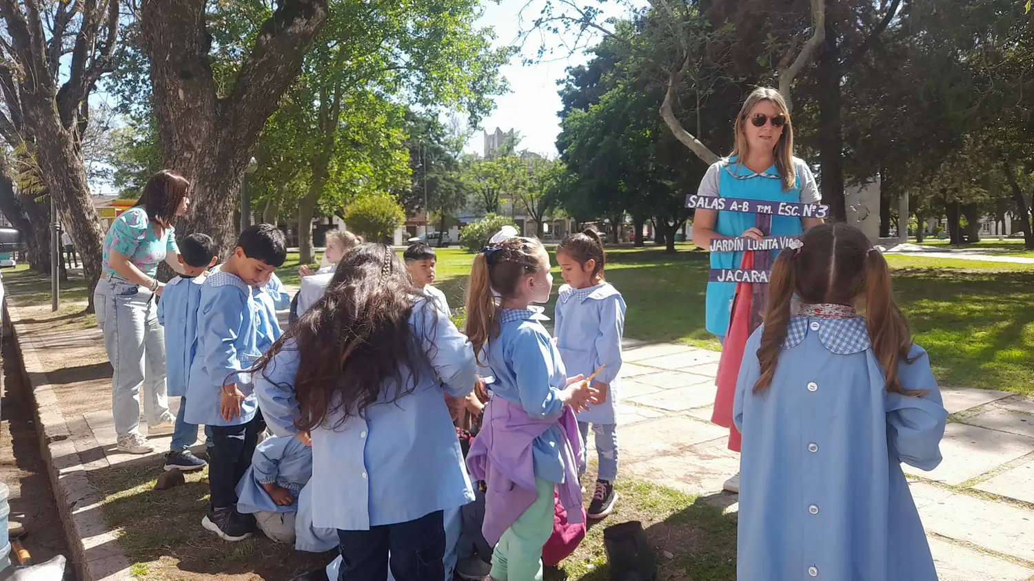 Niños de jardín de infantes plantan jacarandáes