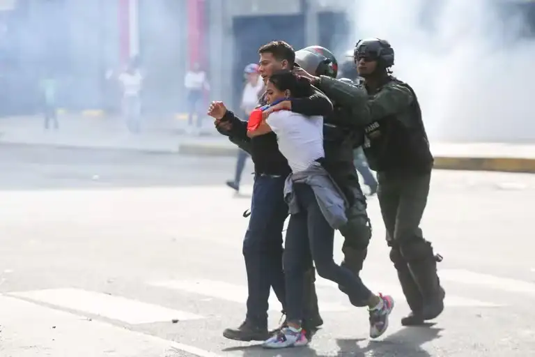 Integrantes de la Guardia Nacional Bolivariana detienen a dos jóvenes durante una protesta contra los resultados divulgados por el Consejo Nacional Electoral el 29 de julio en Caracas