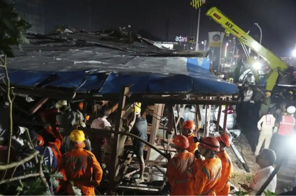 Bomberos observan los destrozos provocados por la caída de la valla publicitaria