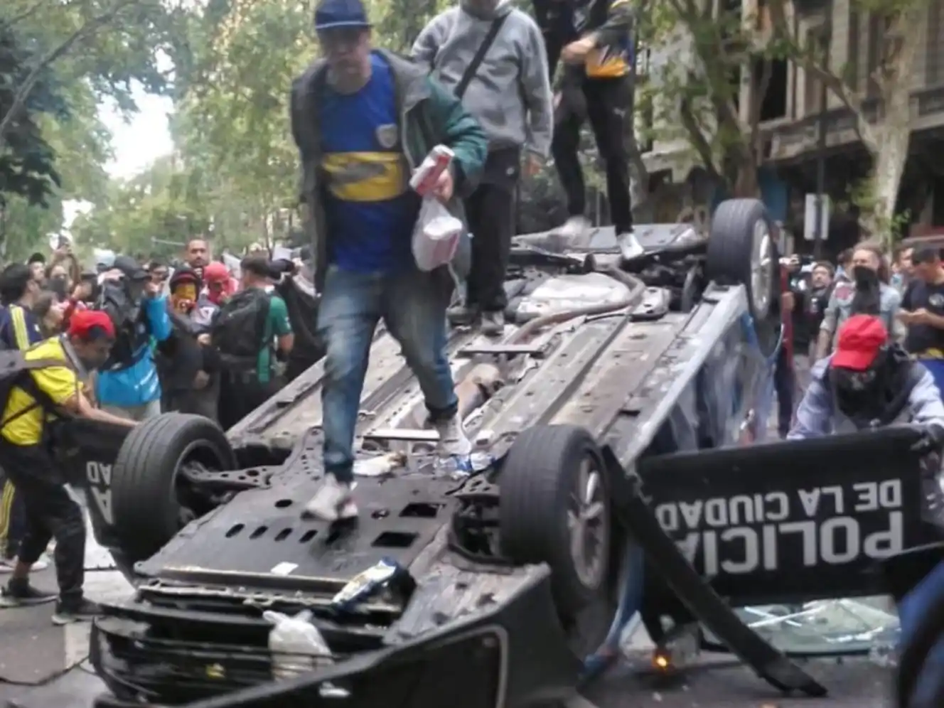 Violencia. Manifestantes sobre un auto de la Policía de la Ciudad que luego fue incendiado.