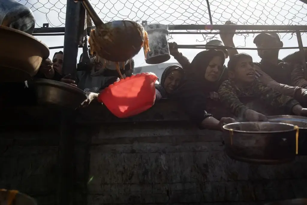 Palestinos incluidos niños, se reúnen para recibir alimentos, en Khan Yunis, al sur de la Franja de Gaza. EFE