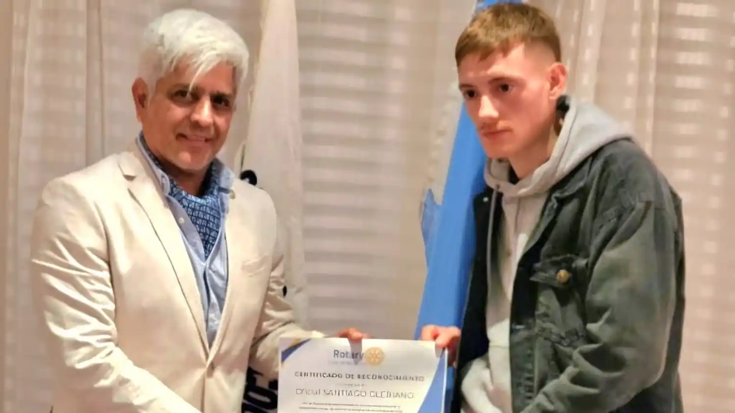 El presidente del Rotary Club, David A. Wall, entrega el reco nocimiento al oficial