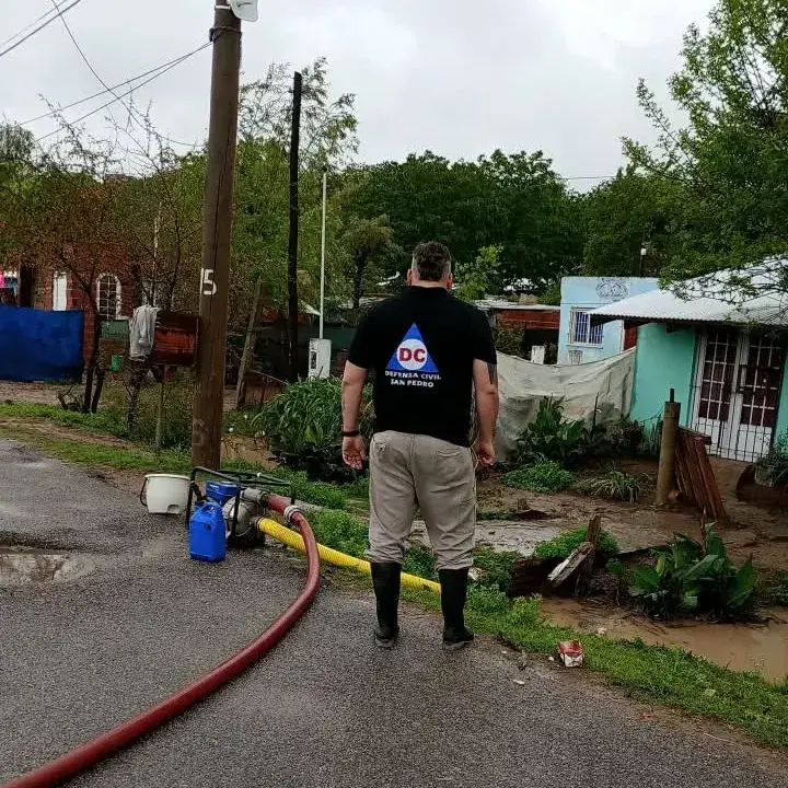 Personal de Defensa Civil trabaja en el barrio Bajo Cementerio utilizando bombas de achique para drenar el agua acumulada en las viviendas tras el fuerte temporal de lluvia que afectó a la zona.