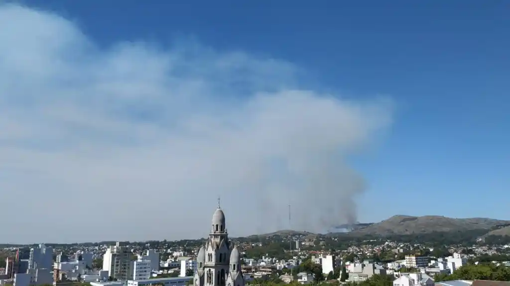Una columna de humo negro que va cubriendo una parte de la ciudad
