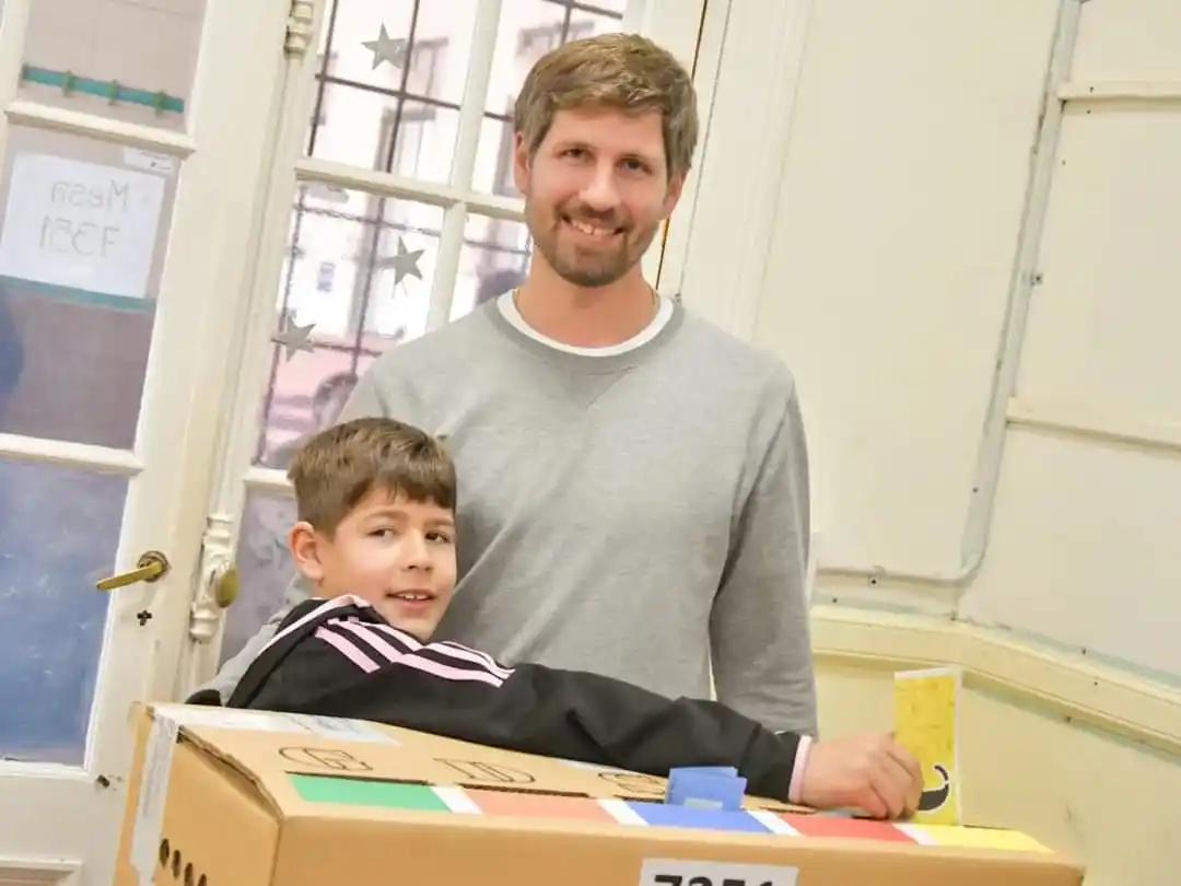 Santiago Meardi y su hijo emitiendo el voto.