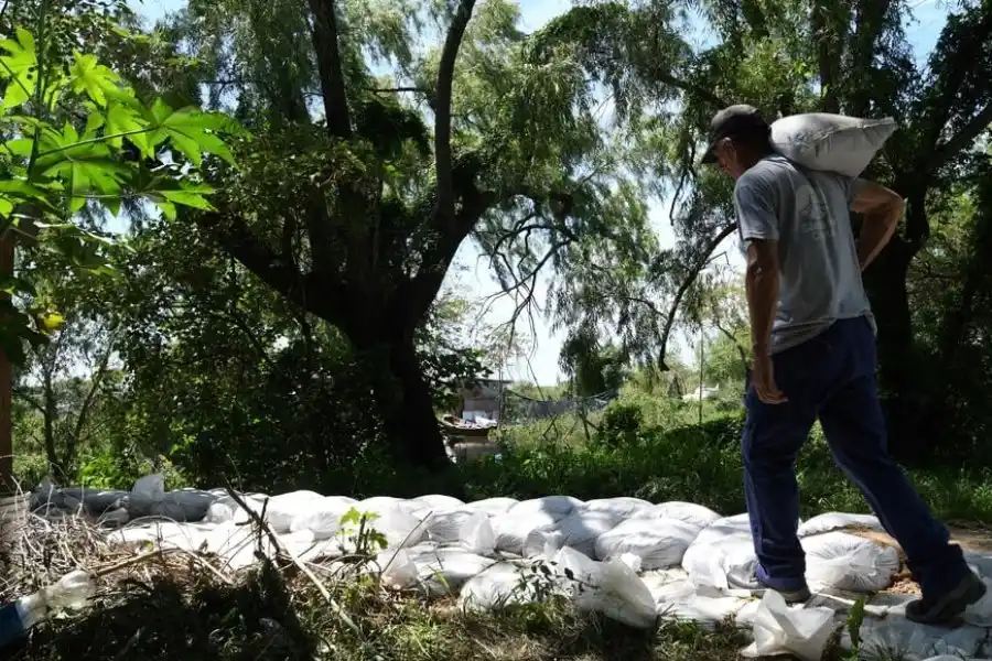 En La Vuelta del Paraguayo, hay familias que huyen de la crecida. Otras resisten haciendo contenciones con bolsas de arena. Mauricio Garín