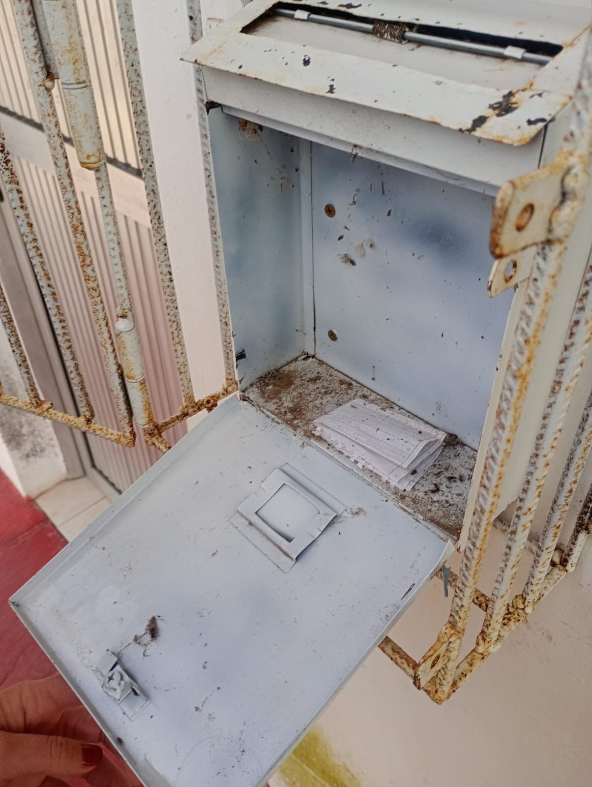 Buzón abierto con una denuncia en su interior.