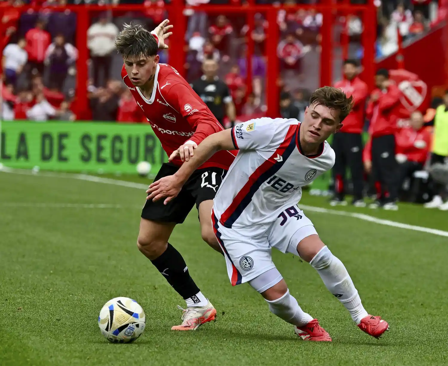 Tarzia y Perruzzi se disputan la posición para llegar a la pelota.