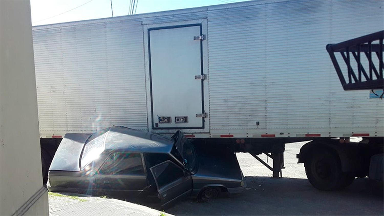 Un camionero no calculó bien para doblar y destrozó un auto estacionado