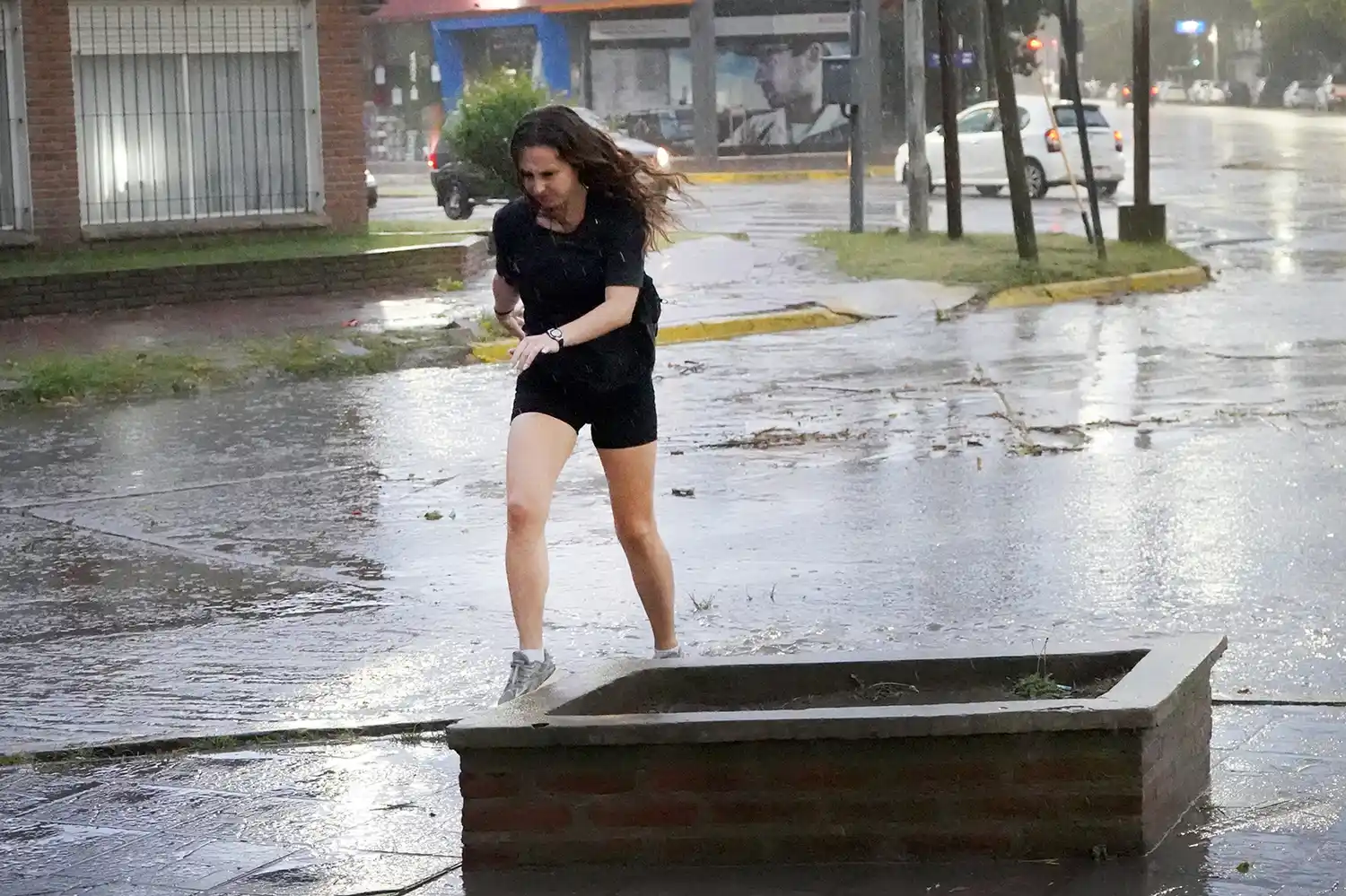 Desafiando al viento. Una joven intenta cruzar la calle