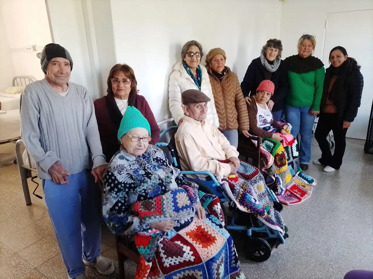 Integrantes de "Las arañitas tejedoras" junto a abuelos del geriátrico.