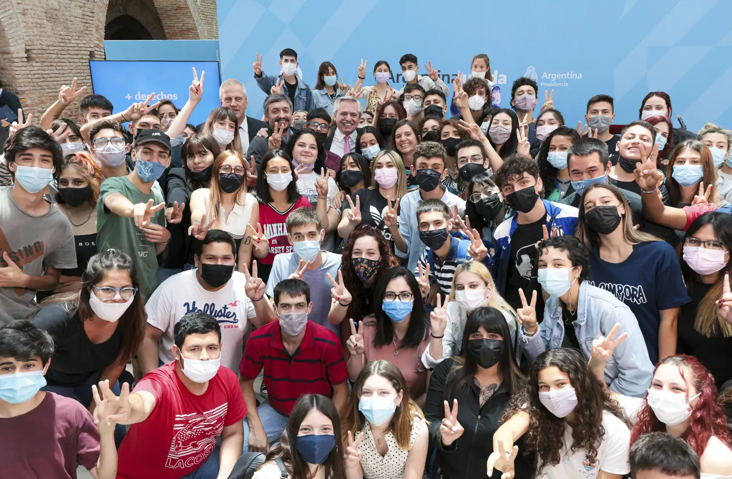 El Presidente y Máximo Kirchner, rodeados por estudiantes.