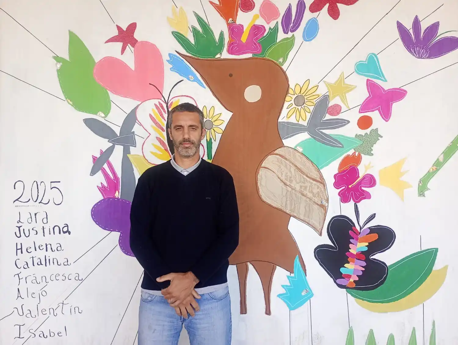 Ignacio Elizari dialogó con La Voz del Pueblo para contar las características principales que tendrá la propuesta en 2026. De fondo, el mural que resultó ganador en 2025, pintado en el estacionamiento de la Cooperativa Obrera de Av. Moreno (3º B del Colegio Holandés, con la docente Magali Beltrame)