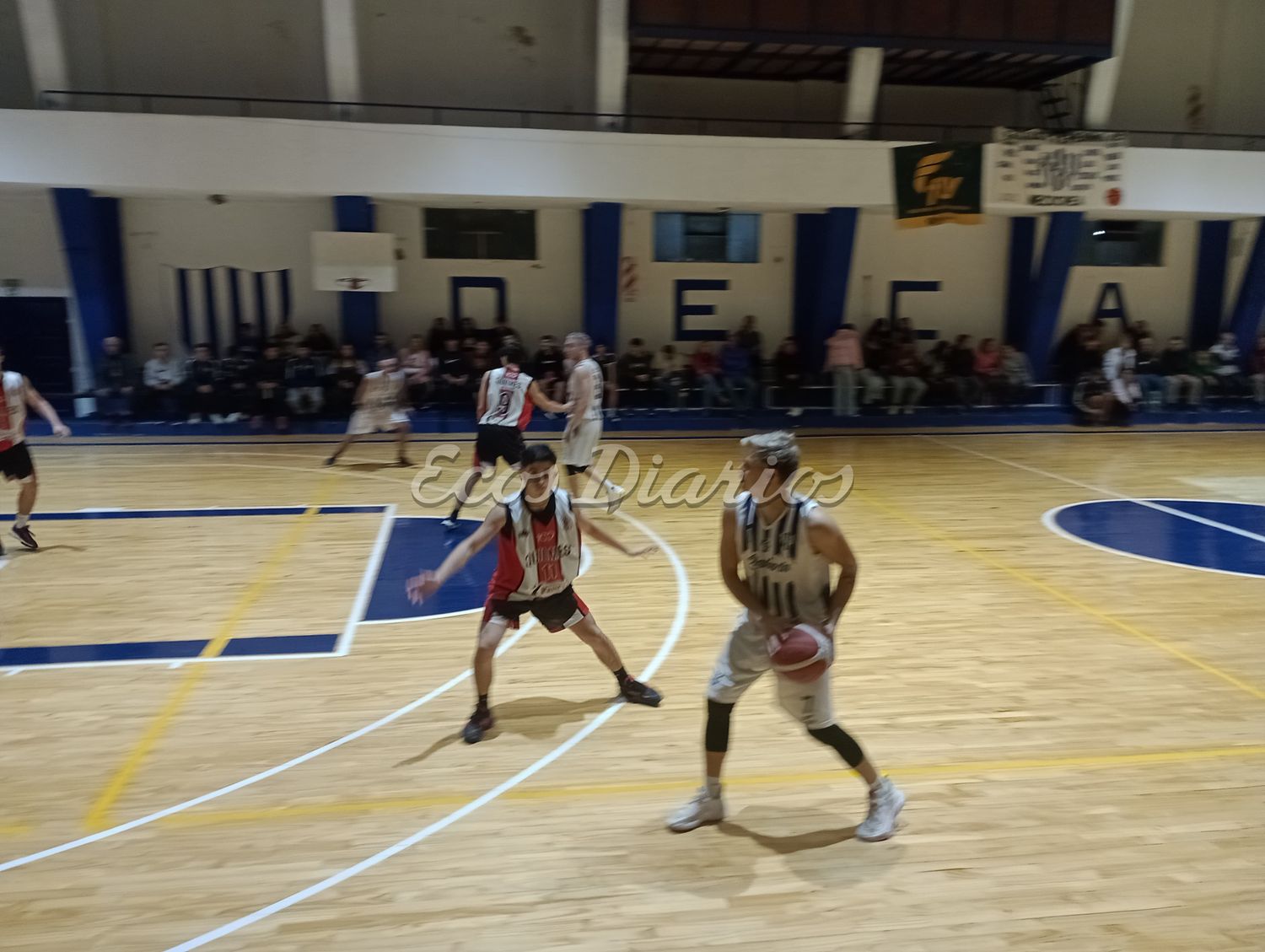 Brian Milobara sostiene el balón, ante la mirada atenta de un rival