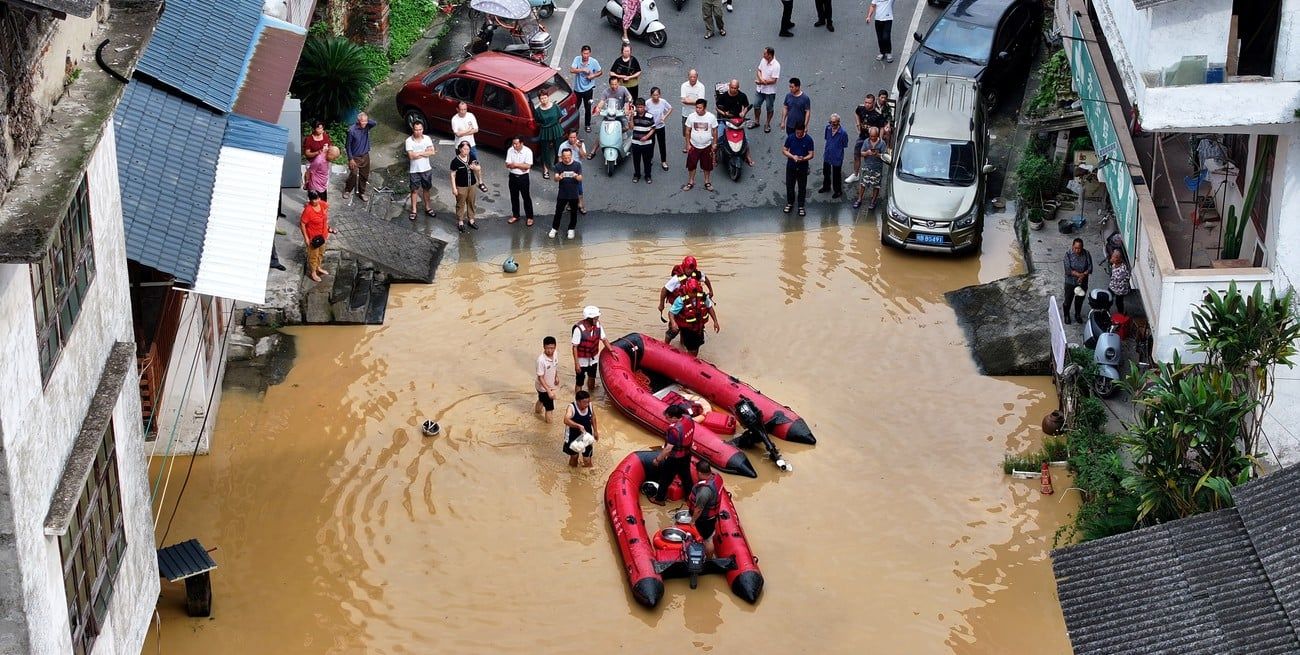 Rescatistas ayudando a residentes a cruzar el agua de la inundación, en el distrito de Rong'an, en la región autónoma de la etnia zhuang de Guangxi, en el sur de China. Crédito: Xinhua/Tan Kaixing