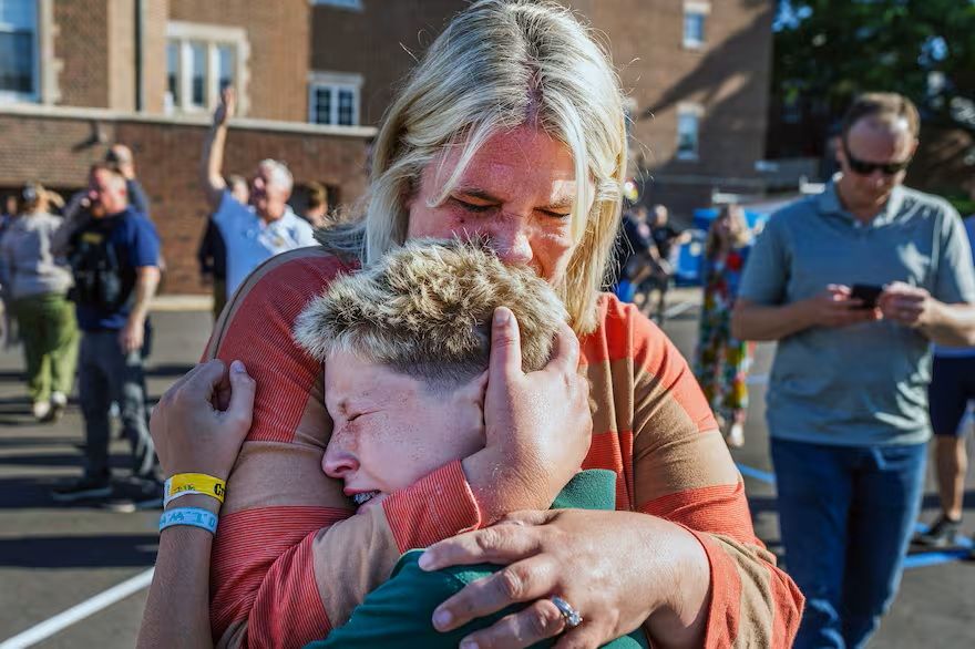 Una madre abraza a su hijo durante una situación de tirador activo en la Iglesia de la Anunciación, en Minneapolis, Minnesota