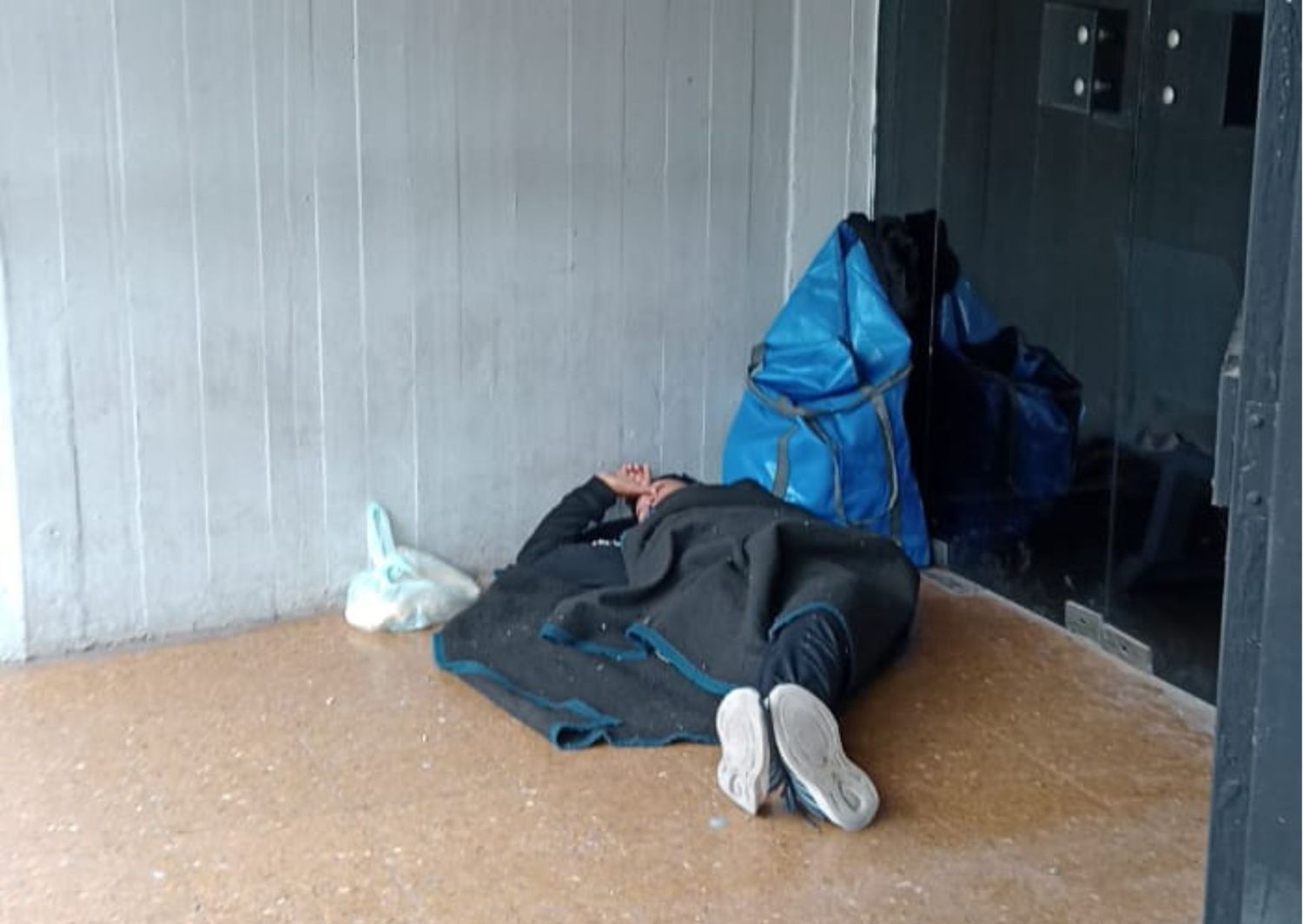 Un hombre durmiendo en la puerta del Hospital