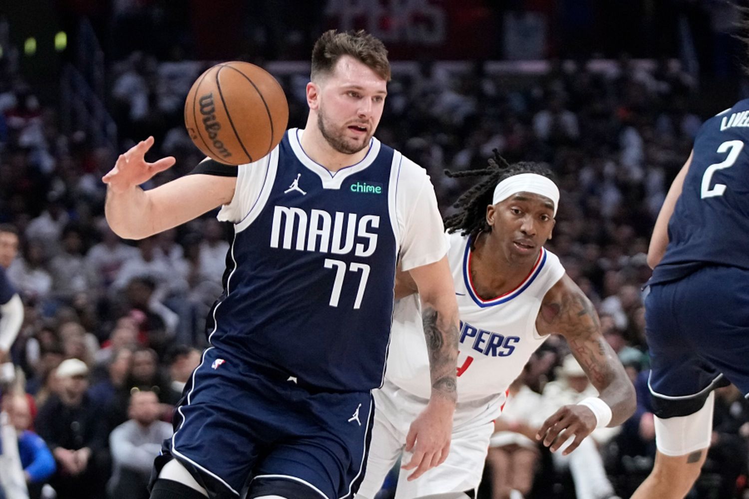 Luka Dončić in action during the game, showcasing his skill and focus on the court.