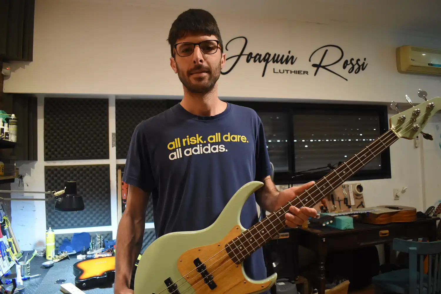 El joven luthier en la intimidad del taller con el bajo parido en su pueblo