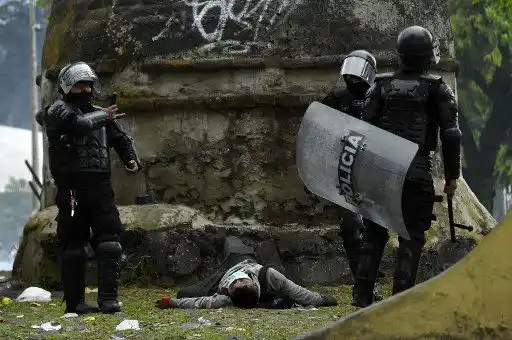 La policía antidisturbios junto a un manifestante herido durante los enfrentamientos en Quito el 24 de junio de 2022, en el marco de las protestas lideradas por indígenas contra el gobierno.