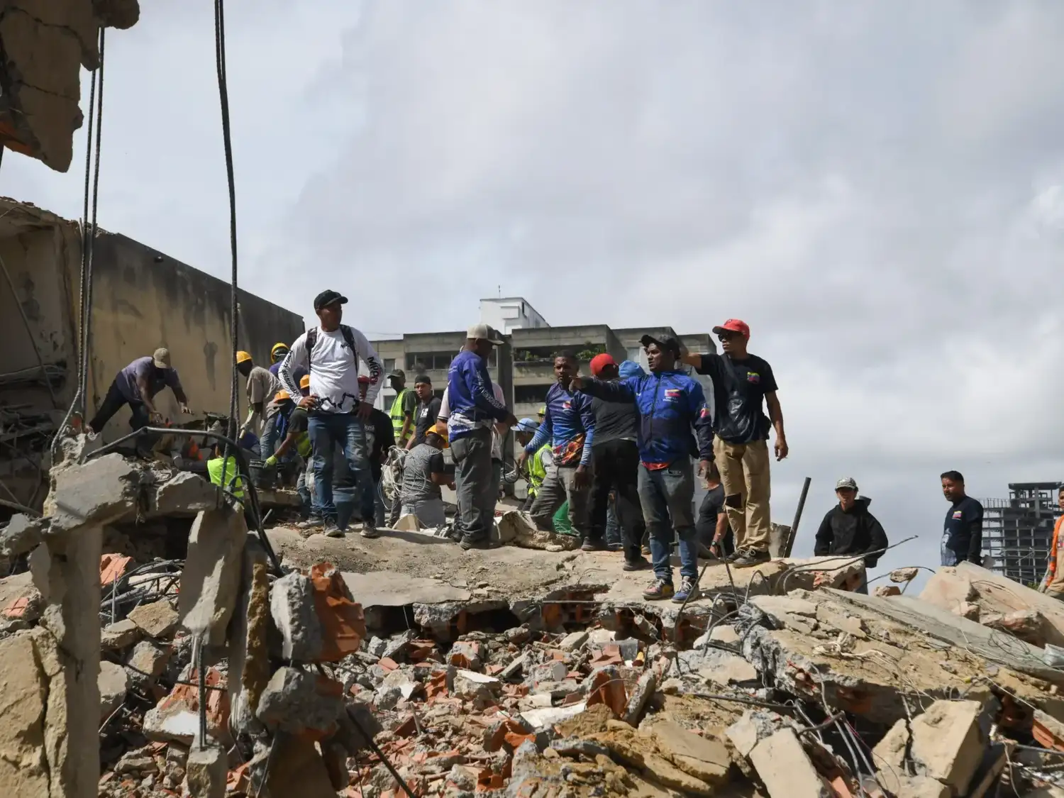 Rescatistas trabajan sobre los escombros de un edificio derrumbado.